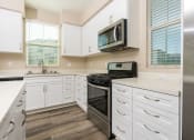 Thumbnail 26 of 60 - a kitchen with white cabinets and appliances