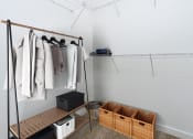 Thumbnail 18 of 60 - a walk in closet with wooden shelves and baskets