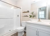 Thumbnail 36 of 60 - a bathroom with a white sink and toilet next to a shower with a glass door