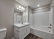 Thumbnail 39 of 83 - A white bathroom with a sink, mirror, and bathtub.