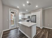 Thumbnail 37 of 83 - A kitchen with white cabinets and a white island.