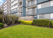 Thumbnail 5 of 86 - exterior of avenue two apartment building with green lawn at Avenue Two Apartments, California, 94063