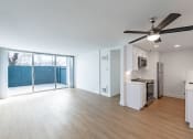 Thumbnail 77 of 86 - an empty living room and kitchen with a sliding glass door to a patio at Avenue Two Apartments, California