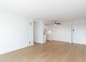 Thumbnail 81 of 86 - an empty living room and kitchen with white walls and wood flooring at Avenue Two Apartments, Redwood City