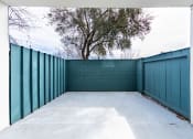 Thumbnail 86 of 86 - a garage with a blue fence and a tree behind it at Avenue Two Apartments, Redwood City  , CA 94063