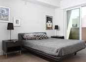 Thumbnail 4 of 26 - A bedroom with a bed, nightstands, and a poster on the wall at Wilshire Valencia Apartment, Los Angeles, 90017