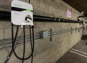 Thumbnail 36 of 50 - a white electricity meter on a brick wall with wires plugged into it