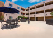 Thumbnail 38 of 50 - a patio with tables and umbrellas in front of a building