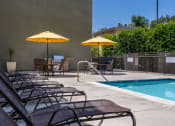 Thumbnail 33 of 50 - a swimming pool with chairs and umbrellas next to it