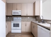 Thumbnail 43 of 50 - a kitchen with white appliances and granite counter tops