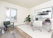 Thumbnail 42 of 77 - a living room with a white rug and a desk with a chair