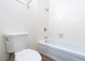 Thumbnail 47 of 77 - a white bathroom with a toilet and a tub