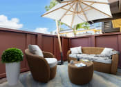 Thumbnail 51 of 77 - a patio with chairs and an umbrella on a balcony
