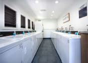 Thumbnail 66 of 77 - a laundry room with white washers and dryers and sinks