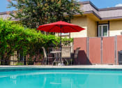 Thumbnail 67 of 77 - a swimming pool with an umbrella in front of a house