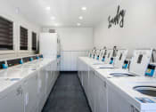 Thumbnail 75 of 77 - a laundry room filled with lots of white washing machines