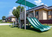Thumbnail 69 of 77 - a playground with a slide in front of a building
