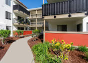 Thumbnail 20 of 36 - an exterior view of an apartment building with a walkway and plants