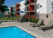 Thumbnail 11 of 36 - the pool area of California Villages Pico Rivera with chairs and a swimming pool
