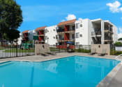 Thumbnail 12 of 36 - a swimming pool in front of an apartment building