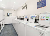 Thumbnail 38 of 91 - A laundry room with washing machines and a sign that says "Laundry".
