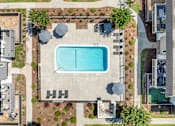 Thumbnail 47 of 91 - A pool surrounded by a concrete fence and a small garden.