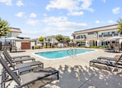 Thumbnail 1 of 91 - A pool with sun loungers and a building in the background.