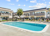 Thumbnail 44 of 91 - A swimming pool in front of a building with a fence around it.