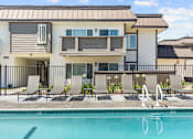 Thumbnail 50 of 91 - A swimming pool in front of a modern two-story apartment building.