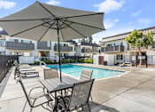 Thumbnail 52 of 91 - A patio with a table and chairs and an umbrella over it.