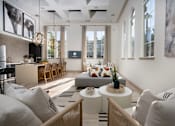 Thumbnail 44 of 52 - A modern living room with a kitchen area in the background at Capriana at Chino Hills, California, 91709
