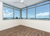 Thumbnail 44 of 127 - A room with a ceiling fan and large windows overlooking a cityscape.