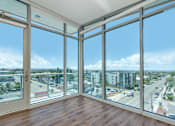 Thumbnail 39 of 127 - A room with a view of a cityscape through large windows.