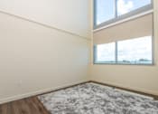 Thumbnail 33 of 127 - A room with a large rug and a window with a view of the sky.