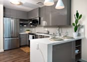 Thumbnail 25 of 127 - A modern kitchen with a white island and stainless steel appliances.