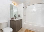 Thumbnail 35 of 127 - A white bathroom with a toilet, sink, and bathtub.