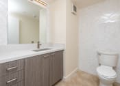 Thumbnail 30 of 127 - A bathroom with a toilet, sink, and mirror.