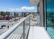 Thumbnail 41 of 127 - A balcony overlooks a street with cars and buildings.