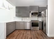 Thumbnail 20 of 127 - A modern kitchen with stainless steel appliances and wooden floors.