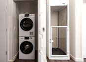 Thumbnail 18 of 127 - A white washing machine and dryer in a small laundry room.
