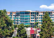 Thumbnail 89 of 127 - A large multi-story building with a red awning in front of it.