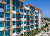 Thumbnail 87 of 127 - A modern multi-story building with balconies and large windows.