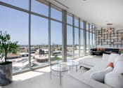 Thumbnail 10 of 127 - A living room with a view of the cityscape outside the large windows.