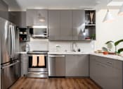 Thumbnail 60 of 127 - A modern kitchen with stainless steel appliances and wooden floors.