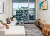 Thumbnail 62 of 127 - A modern living room with a white sofa, a coffee table, and a large window.
