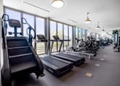 Thumbnail 74 of 127 - A gym with treadmills, elliptical machines, and a stair climber.