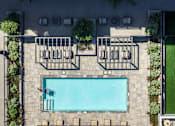 Thumbnail 84 of 127 - A swimming pool surrounded by a concrete patio and a green lawn.