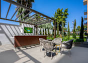 Thumbnail 81 of 127 - A patio with a table and chairs under a pergola.