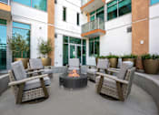 Thumbnail 83 of 127 - A patio with a fire pit and chairs.