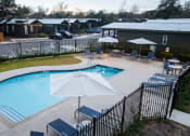Thumbnail 84 of 97 - South Austin, TX, Apartments - Casata Austin - Resort-Style Swimming Pool With Lounge Seats, Tables, Chairs, And Umbrellas